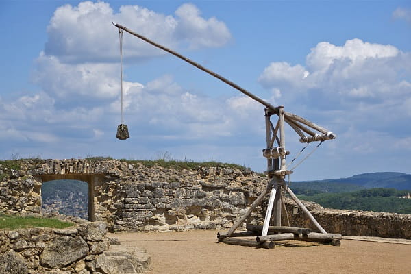 A reconstructed wooden trebuchet on a castle wall