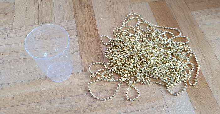A cup and a long bead chain on a table