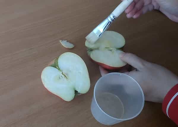 Applying lemon juice to apple